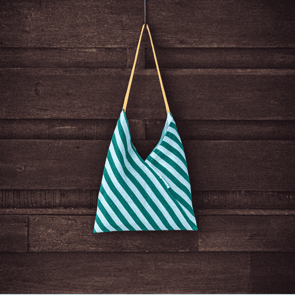 Glas Jai, Should Sling Bag Small. Wall Shot, Vibrant Colours against a dark background.